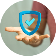 Hand reaching forward to hold a 3D blue shield icon with a check mark, symbolizing security, protection, and trust; softly blurred background emphasizing safety, reliability, and assurance, with a modern circular format.
