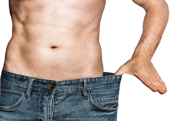Man showcasing his toned midsection while holding oversized denim jeans, highlighting significant weight loss and body transformation; confident posture against a plain black background, emphasizing the contrast between his physique and the loose clothing.